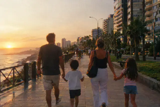Familia caminando de la mano por el Malecón de Miraflores, en Lima, al atardecer